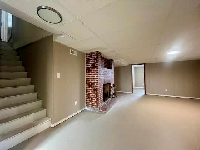 basement with a brick fireplace, a paneled ceiling, and carpet