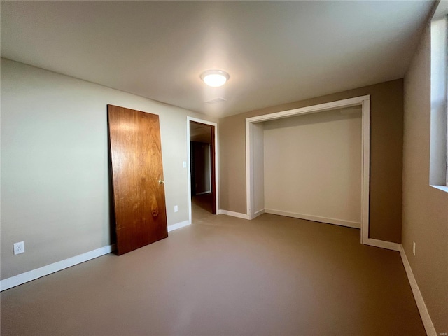 unfurnished bedroom with concrete floors and a closet