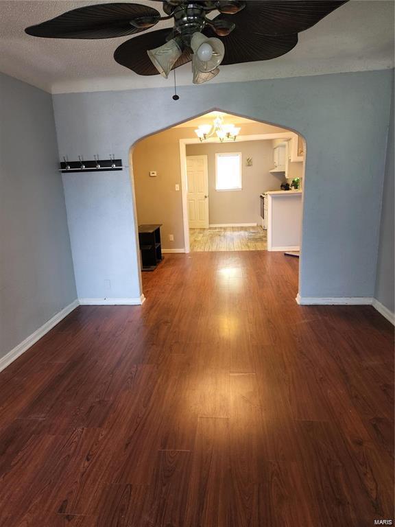 unfurnished living room with hardwood / wood-style flooring, ceiling fan, and a textured ceiling