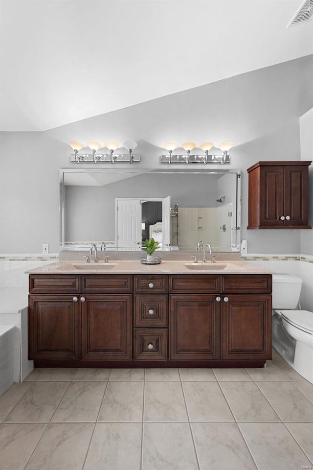 full bathroom with lofted ceiling, vanity, toilet, and shower with separate bathtub