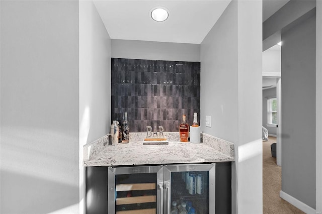 bar featuring tasteful backsplash, beverage cooler, and carpet flooring