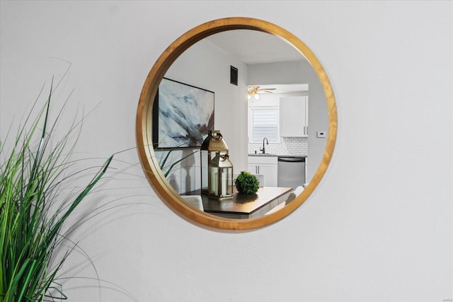 details featuring backsplash, stainless steel dishwasher, sink, and ceiling fan