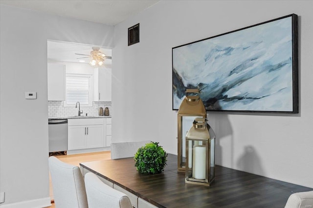 dining room featuring sink, hardwood / wood-style flooring, and ceiling fan