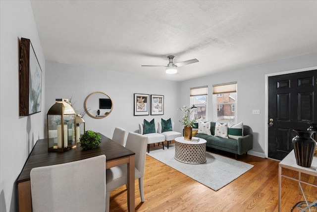 living room with ceiling fan, hardwood / wood-style floors, and a textured ceiling