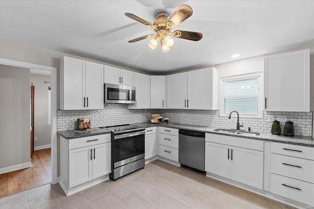 kitchen with white cabinetry, sink, tasteful backsplash, and stainless steel appliances