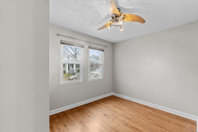 unfurnished room featuring ceiling fan, light hardwood / wood-style flooring, and a textured ceiling