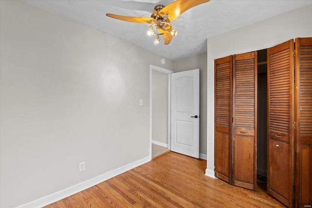 unfurnished bedroom with ceiling fan, a closet, and light hardwood / wood-style flooring