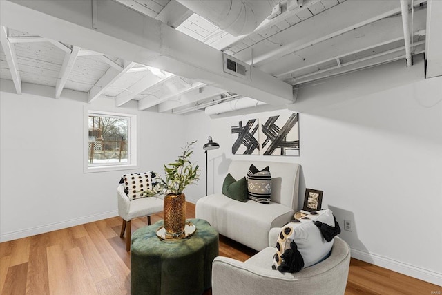 living room featuring beamed ceiling and wood-type flooring