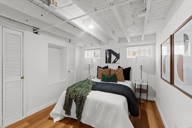 bedroom featuring wood ceiling, hardwood / wood-style floors, and beam ceiling