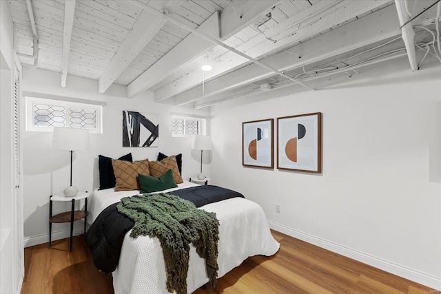 bedroom with beamed ceiling, wood ceiling, and wood-type flooring