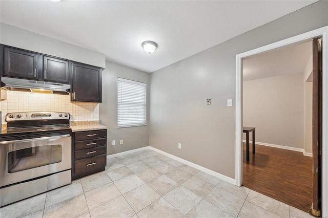 kitchen with dark brown cabinetry, stainless steel electric range oven, light tile patterned floors, and backsplash