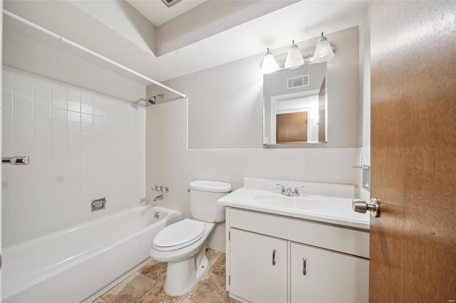 full bathroom featuring tile walls, vanity, tile patterned floors, toilet, and tiled shower / bath