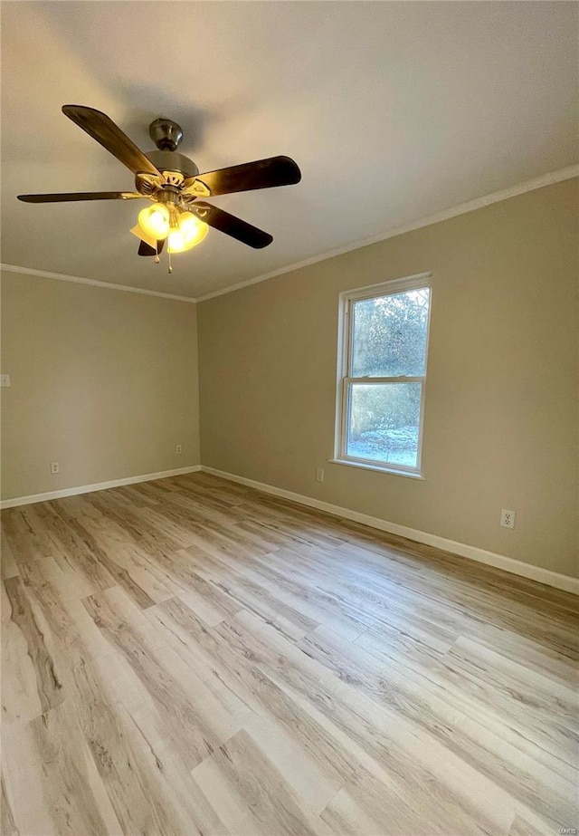 empty room featuring crown molding, baseboards, and wood finished floors