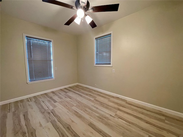 unfurnished room with light wood finished floors, a ceiling fan, and baseboards