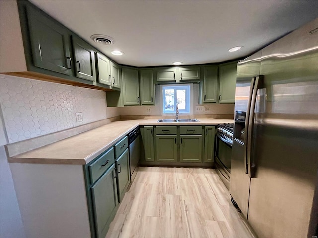 kitchen featuring stainless steel appliances, sink, green cabinets, and light hardwood / wood-style floors