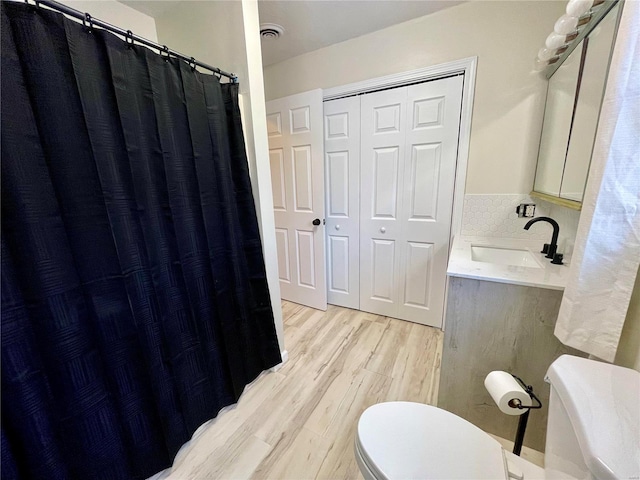 bathroom with tasteful backsplash, vanity, hardwood / wood-style floors, and toilet