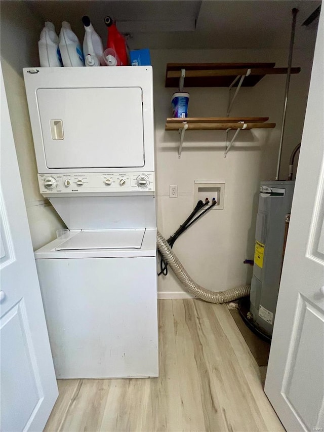 laundry room featuring water heater, stacked washer and clothes dryer, and light hardwood / wood-style floors