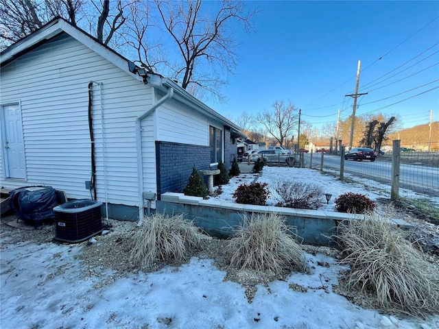 snow covered property featuring central air condition unit