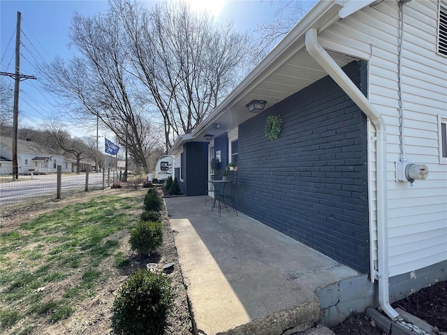 view of home's exterior featuring fence and brick siding