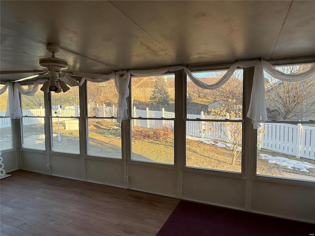 unfurnished sunroom featuring ceiling fan