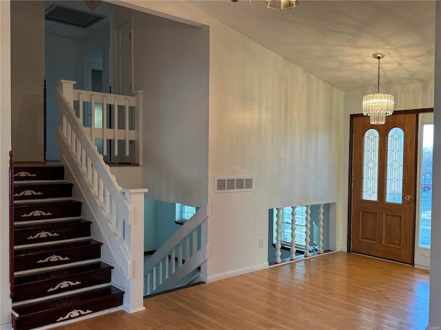 foyer with hardwood / wood-style floors, a textured ceiling, and a healthy amount of sunlight