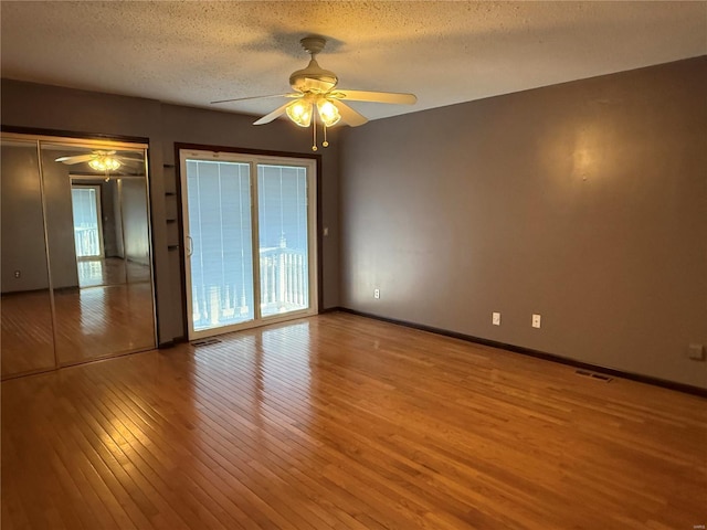 unfurnished room featuring ceiling fan, a textured ceiling, and light wood-type flooring