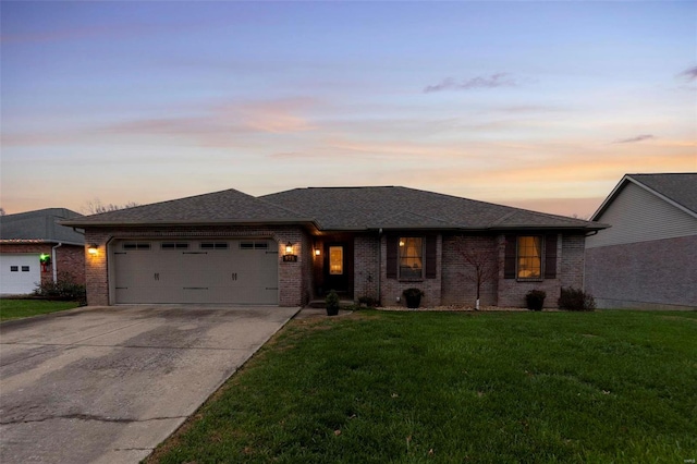 view of front of home with a garage and a lawn