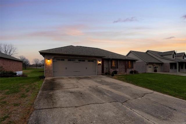 ranch-style home with a garage and a lawn