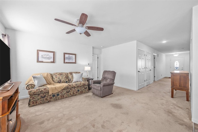 carpeted living room with ceiling fan