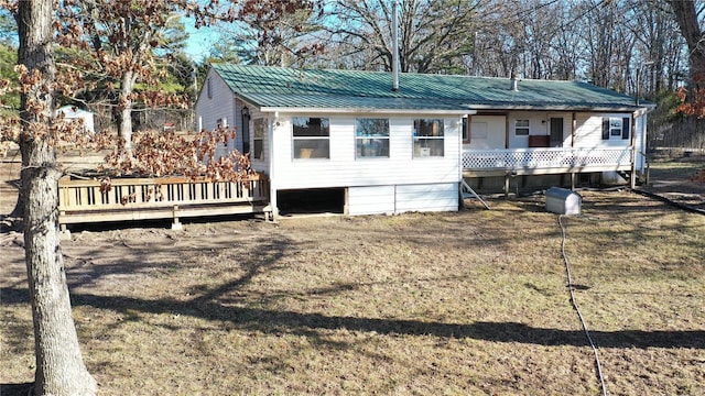 view of front of property featuring a wooden deck and a front yard