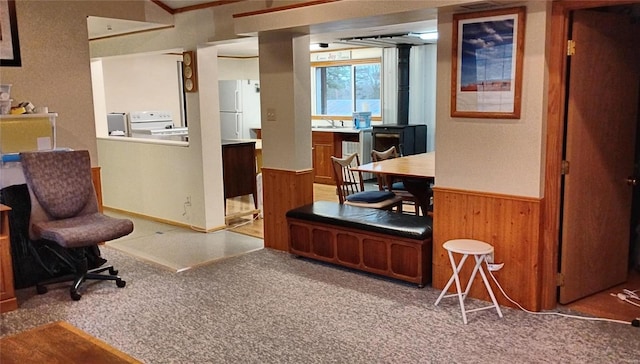 carpeted office featuring sink and wood walls