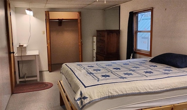 bedroom featuring a drop ceiling and a closet