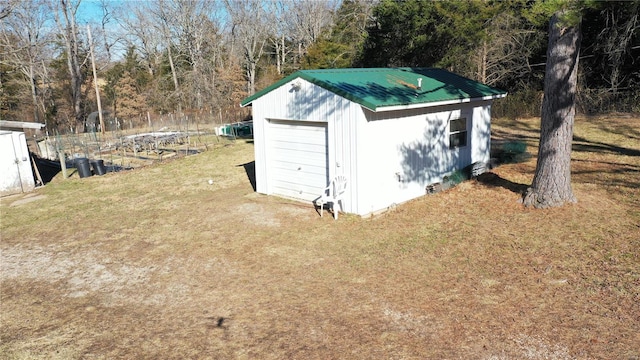 view of outdoor structure with a garage and a lawn