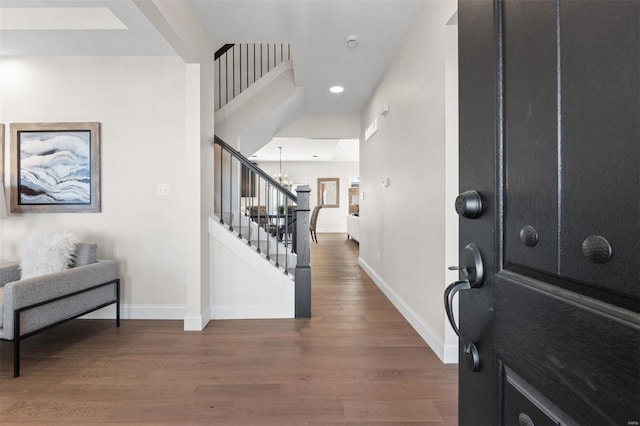 entryway with dark wood-type flooring and an inviting chandelier