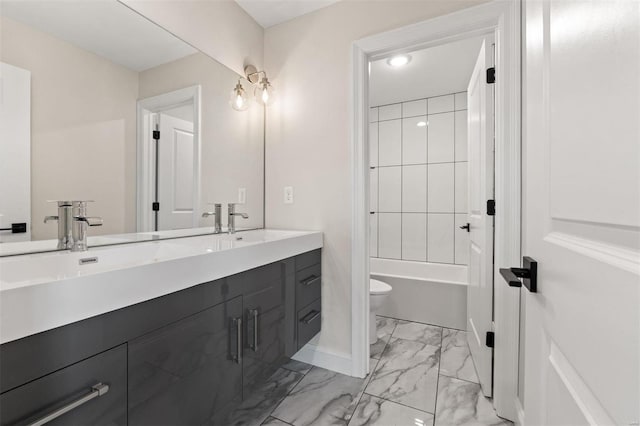 full bathroom featuring tiled shower / bath, vanity, and toilet