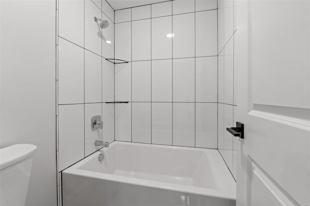 bathroom featuring tiled shower / bath and toilet