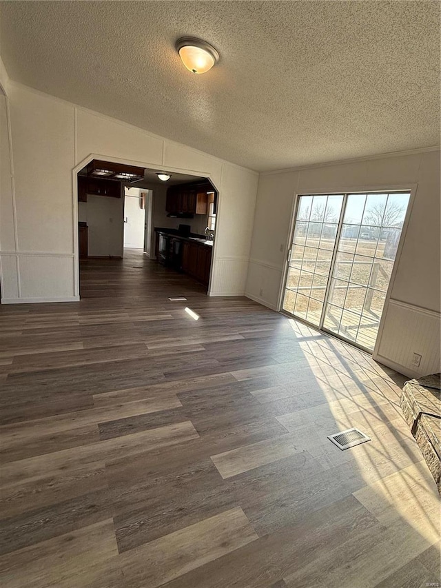 unfurnished living room featuring dark hardwood / wood-style floors and a textured ceiling