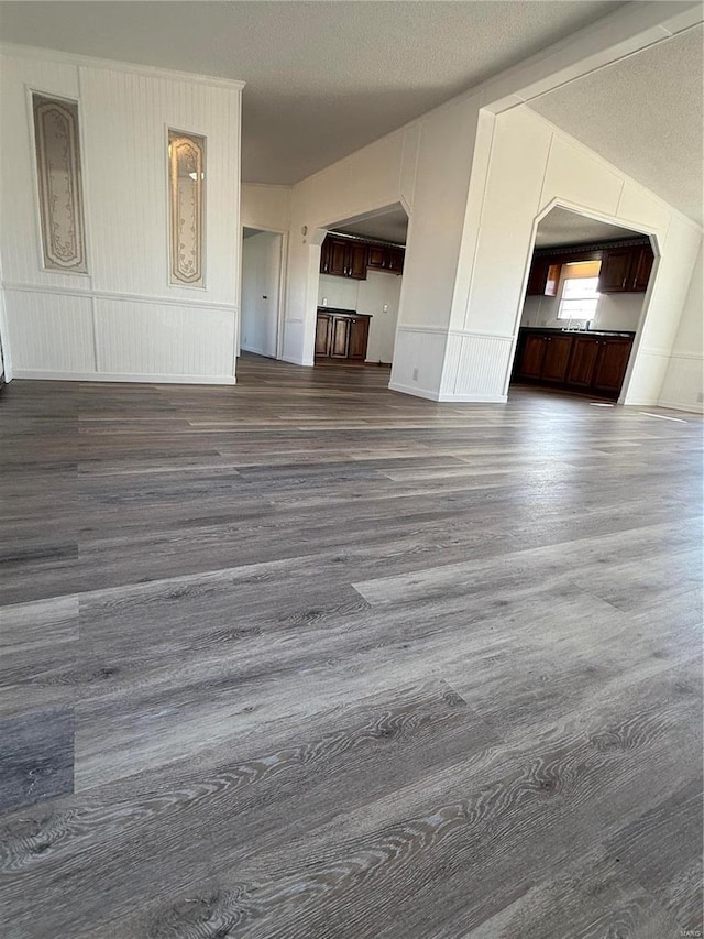 unfurnished living room with wood-type flooring and a textured ceiling