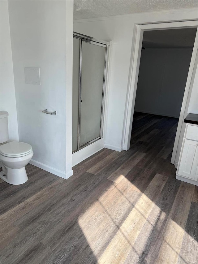 bathroom with hardwood / wood-style flooring, vanity, a shower with door, and a textured ceiling