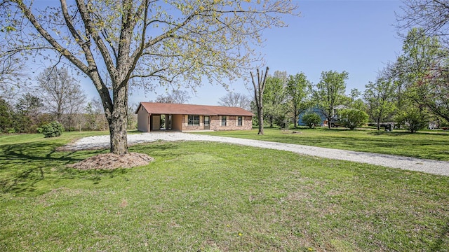 ranch-style home with a front lawn and curved driveway
