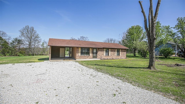 ranch-style house featuring driveway and a front lawn