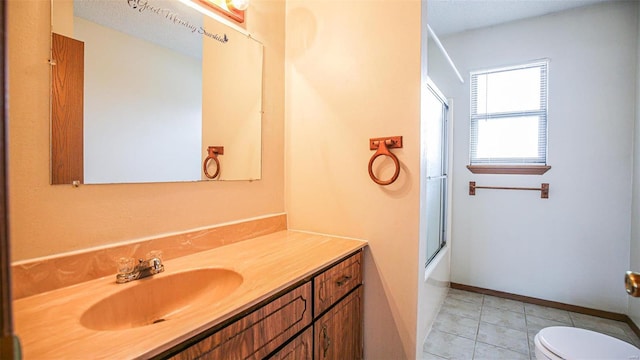 bathroom with tile patterned floors, bath / shower combo with glass door, toilet, baseboards, and vanity