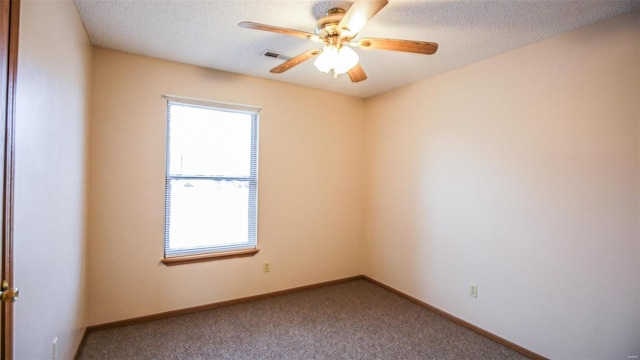 carpeted spare room with baseboards, a ceiling fan, visible vents, and a textured ceiling