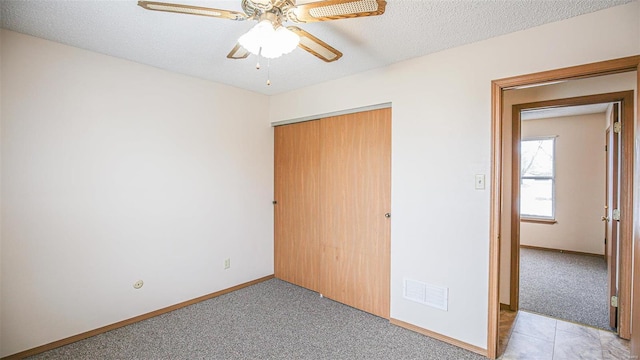 unfurnished bedroom with baseboards, visible vents, a closet, and light colored carpet