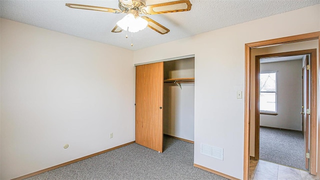 unfurnished bedroom with baseboards, visible vents, light colored carpet, and a closet