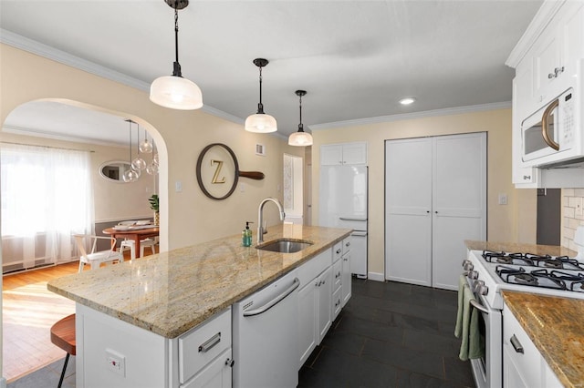 kitchen with sink, white cabinetry, hanging light fixtures, a center island with sink, and white appliances