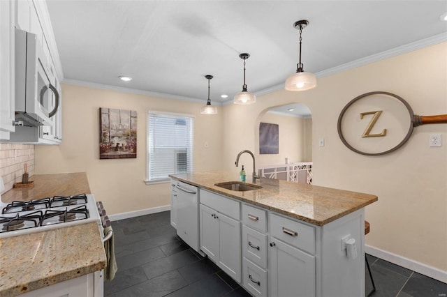 kitchen featuring pendant lighting, an island with sink, sink, white cabinets, and white dishwasher