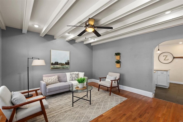 living room featuring hardwood / wood-style floors, beam ceiling, and ceiling fan