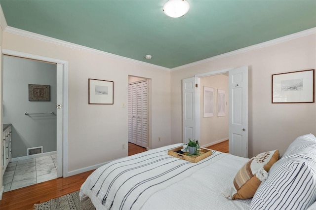 bedroom featuring crown molding, wood-type flooring, and a closet