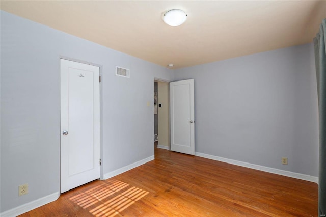 unfurnished room with wood-type flooring